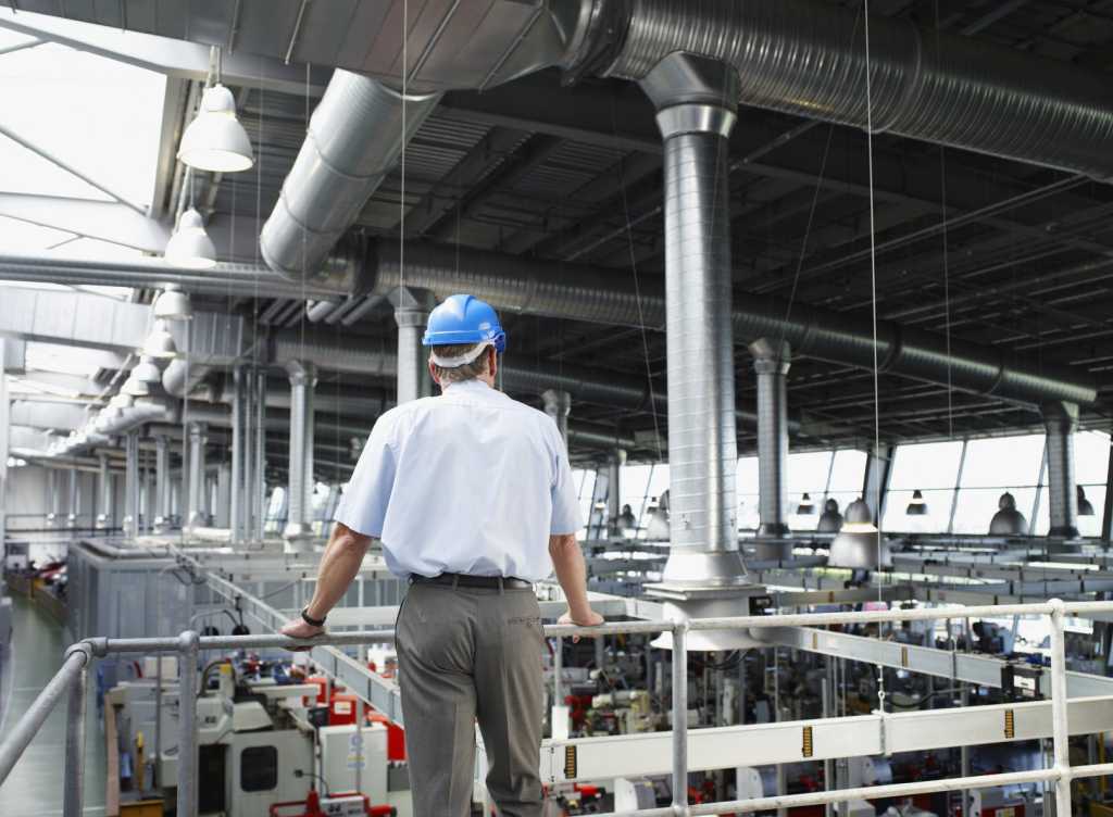 businessman in hardhat looking at factory floor 000024361936 medium