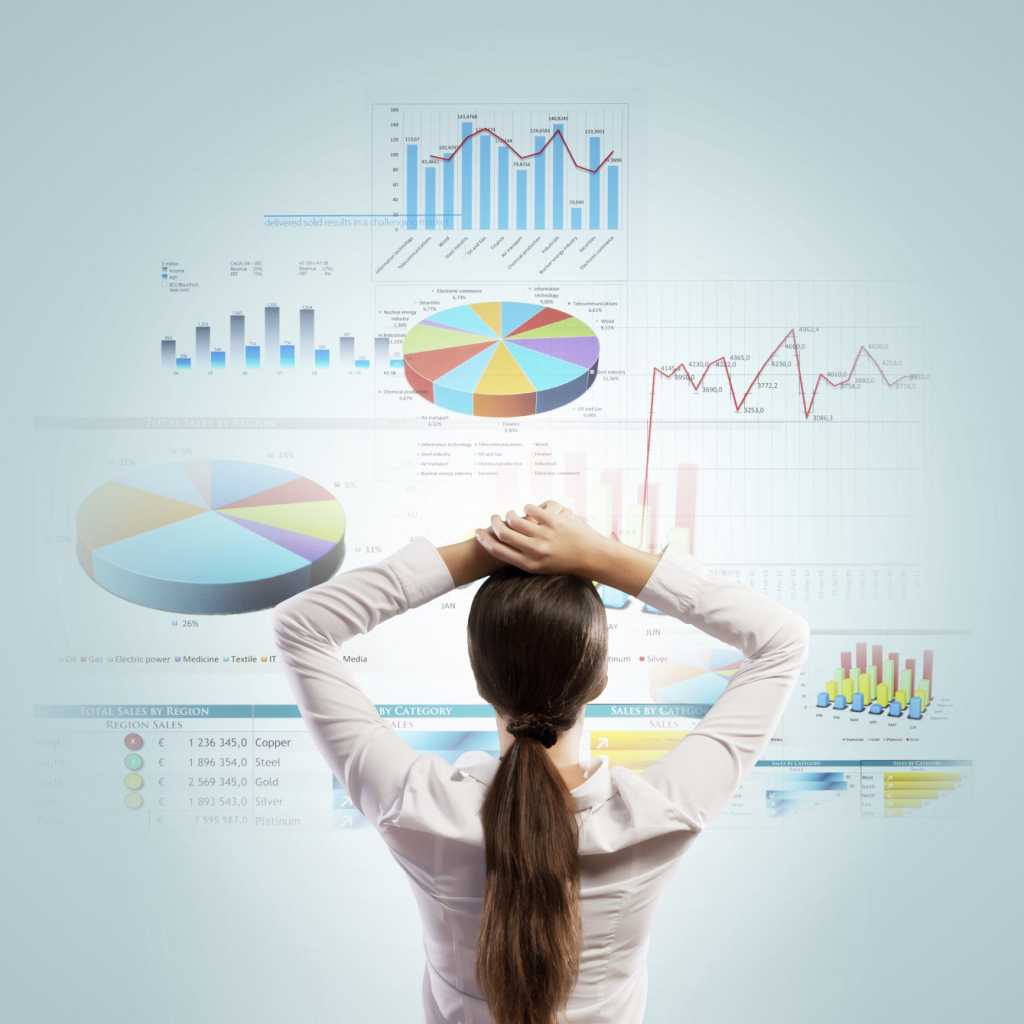 woman standing in front of data chart wall